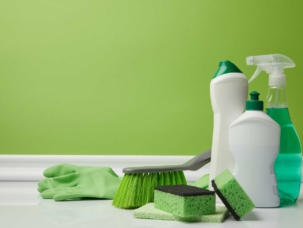 cleaning-bottles-and-supplies-against-green-background